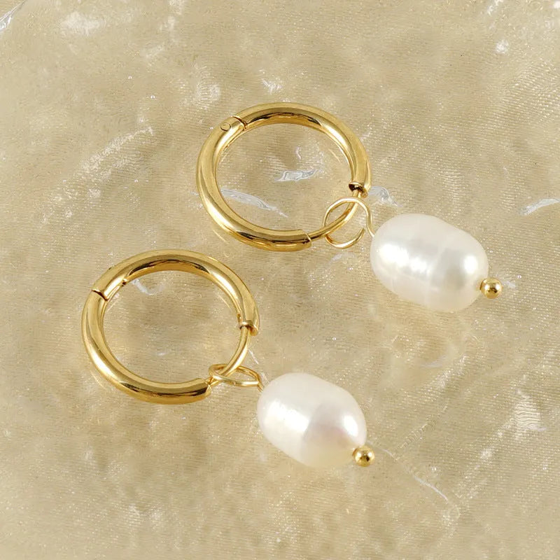 A pair of gold-coloured geometric earrings with a pearl detail, made from stainless steel.