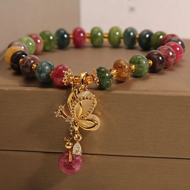 Women's colourful bracelet with alloy butterfly charm and tourmaline beads on wrist.