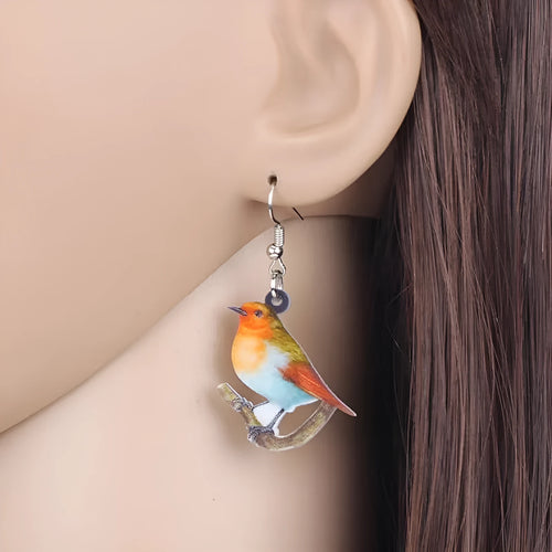 A pair of blue titmouse pendant earrings with printed design on acrylic, featuring geometric and snake elements.
