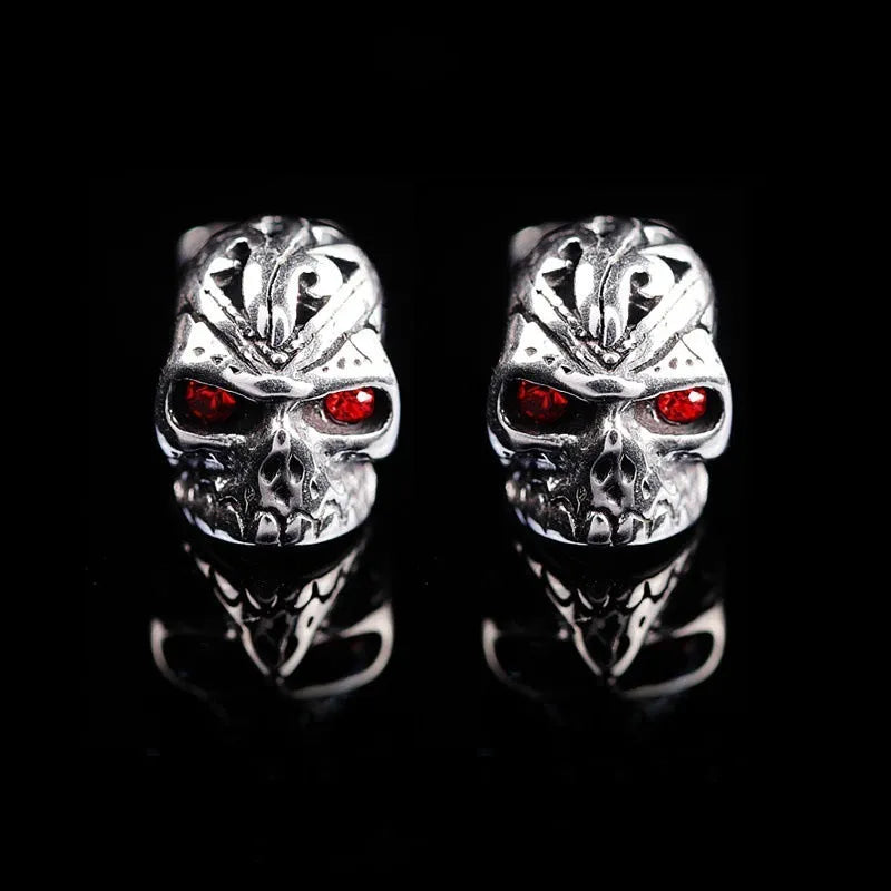 Skull stud earrings with red eye detailing on alloy base with gemstone inlay