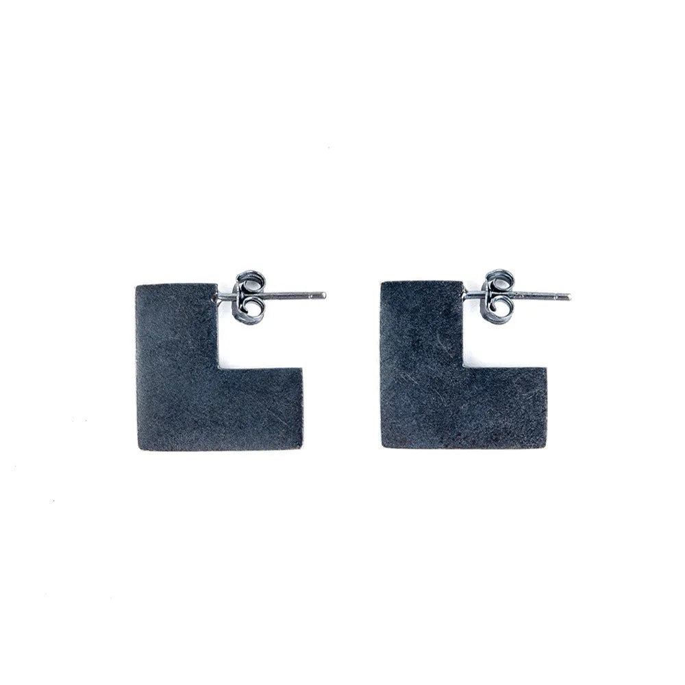 Oxidised black sterling silver square geometric earrings on a white background.