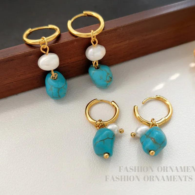 A pair of geometric copper clip-on earrings featuring irregular blue-green turquoise stones and white cultured pearls.