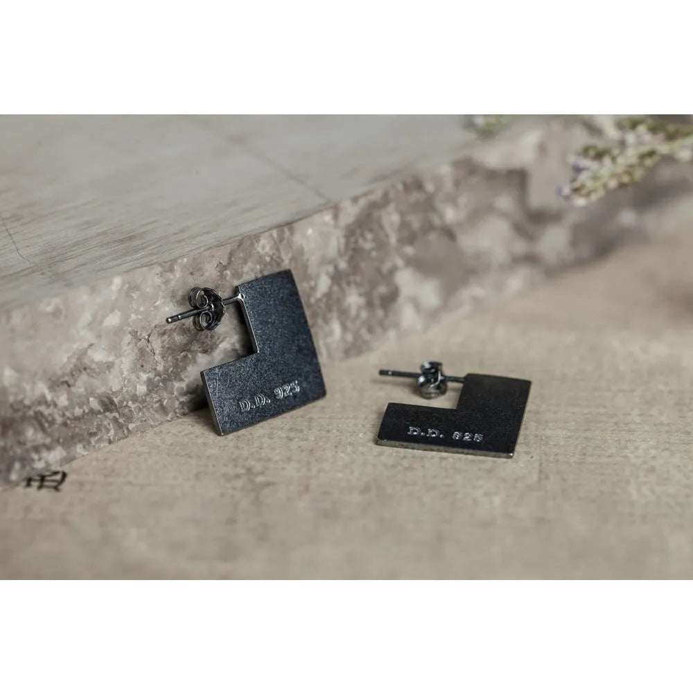 Oxidised black sterling silver square geometric earrings on a white background.