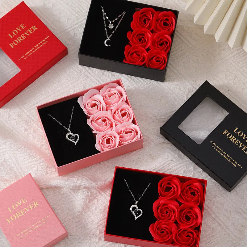 Red Korean-style gift box open to show six pink soap flowers, with a matching red handbag beside it.