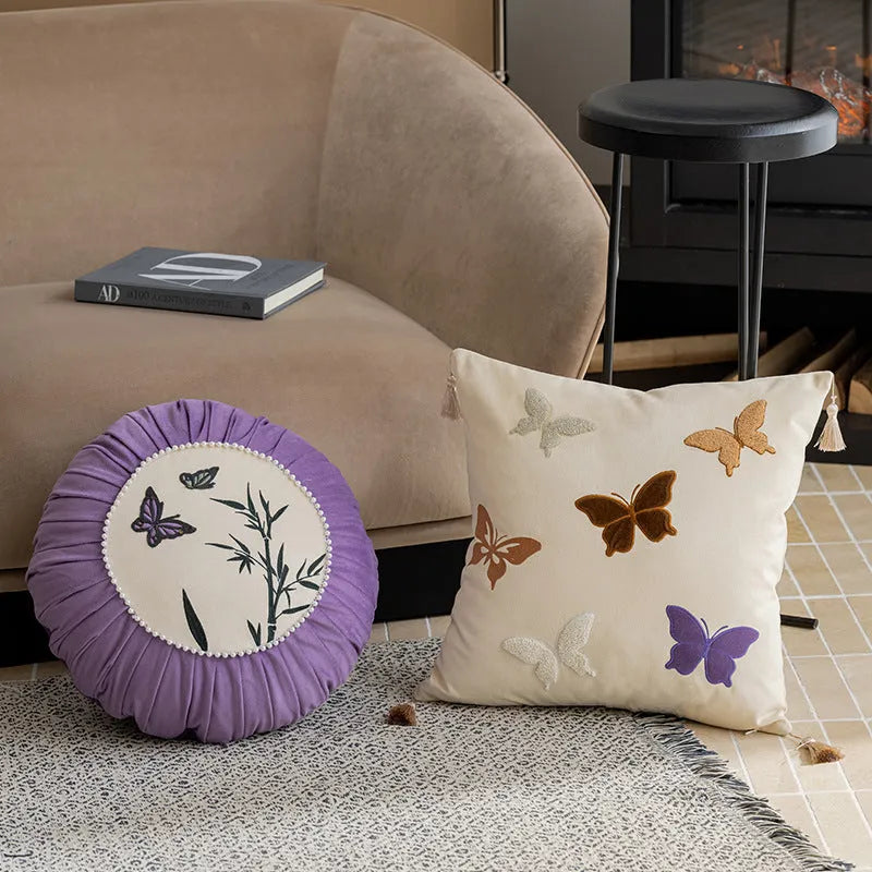 Square beige couch pillow with embroidered Chinese-style butterfly design.