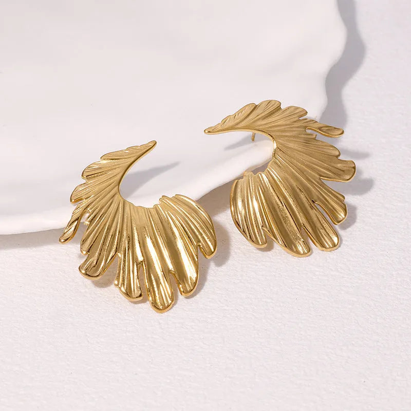 A pair of stainless steel stud earrings in a leaf shape, shown in gold colour and steel colour finishes.
