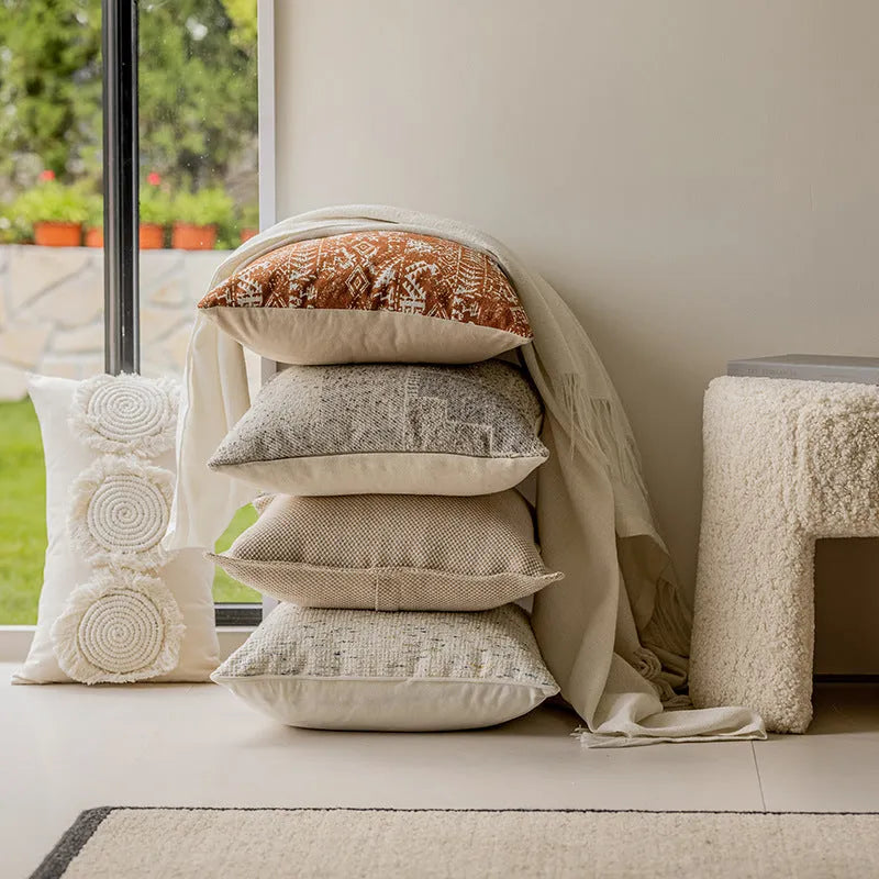 A square pp cotton pillow cushion with a solid red-brown abstract print cover on a sofa.