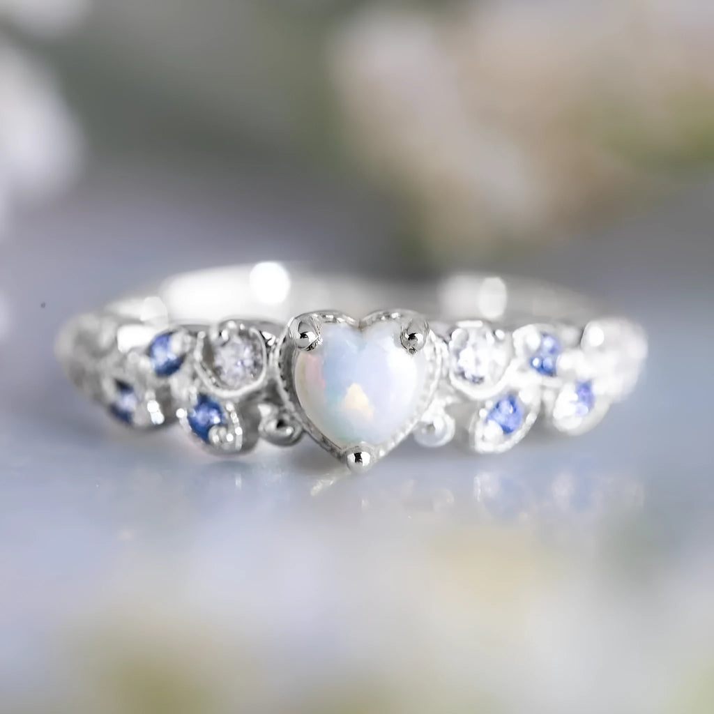 Close-up of a white alloy women's ring with a heart shape and flower opal ocean design.