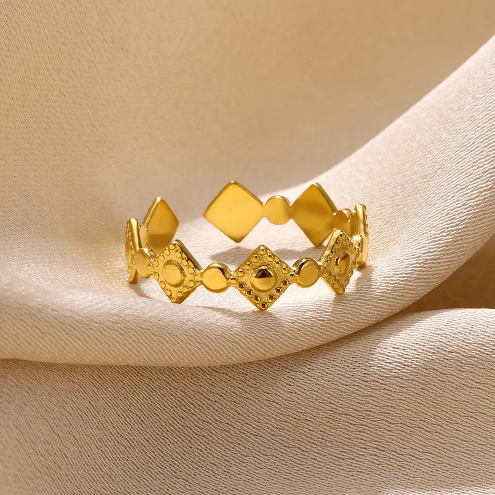 Geometric gold titanium steel ring for women on a white background.