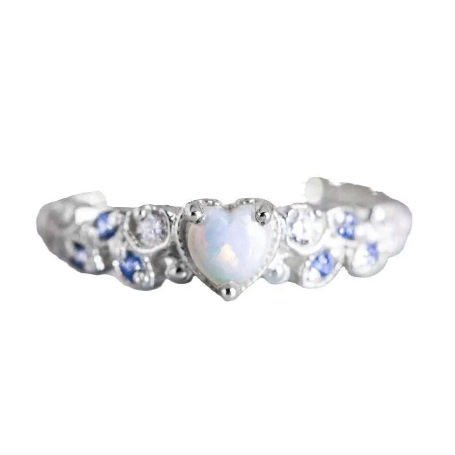 Close-up of a white alloy women's ring with a heart shape and flower opal ocean design.