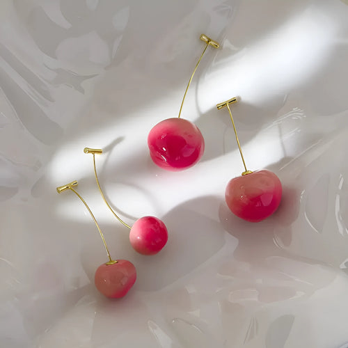 A pair of acrylic peach fruit earrings on copper posts, shown in small and large size options.