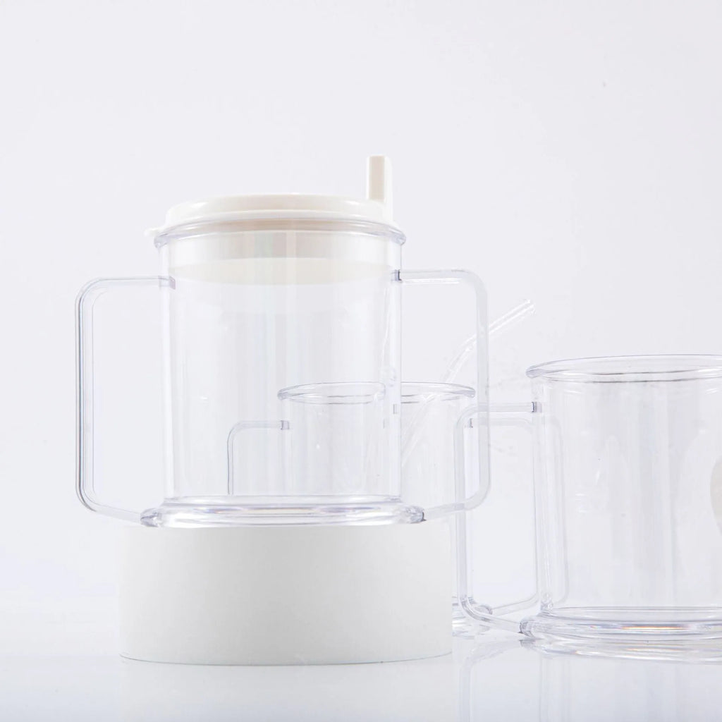 Transparent plastic drinking cup with spill-proof lid on a plain background.