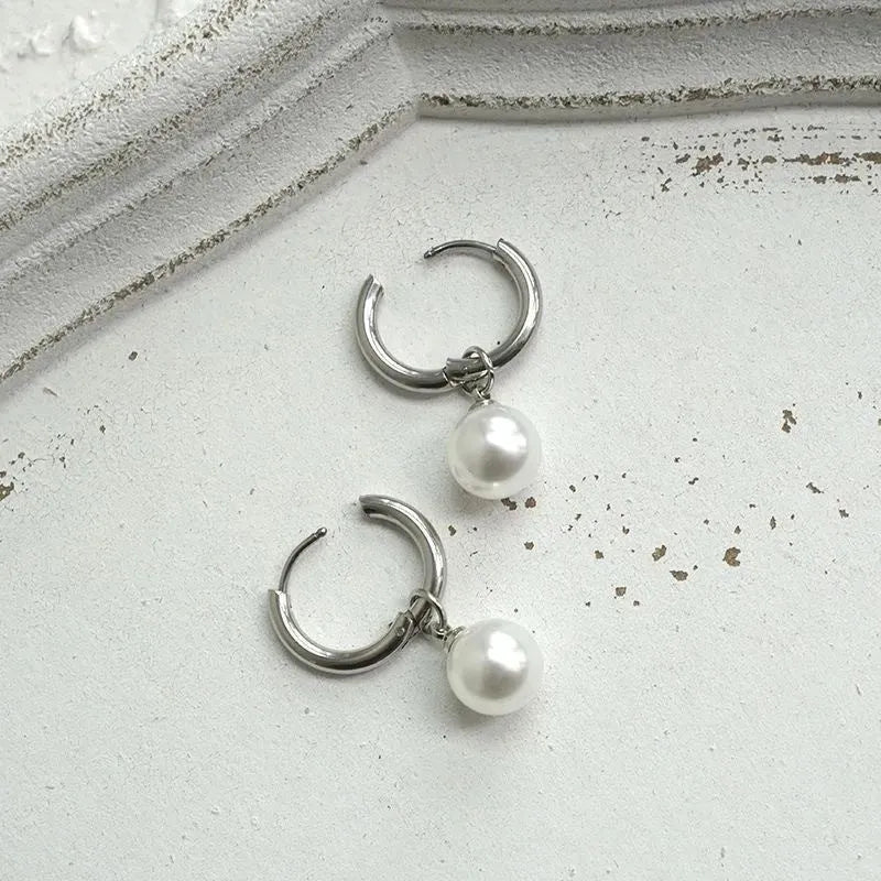 A pair of geometric-style pearl earrings for women with titanium steel posts.