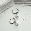 A pair of geometric-style pearl earrings for women with titanium steel posts.