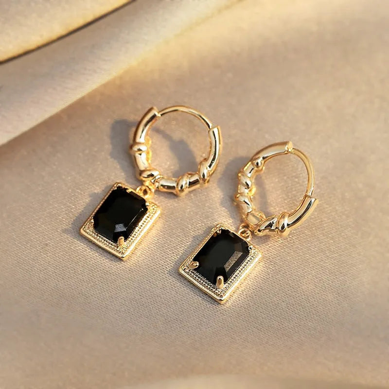 Close-up of black geometric cubic zirconia earrings with a quadrilateral design and butterfly clutch backs.