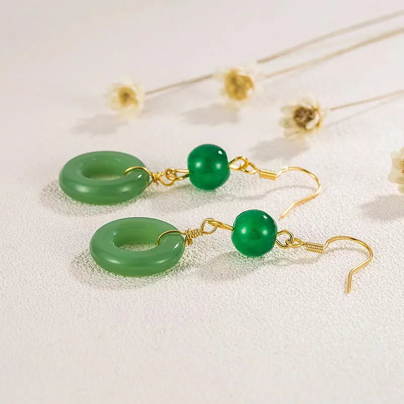 A pair of geometric peace buckle earrings with a green jade design and gold plating.