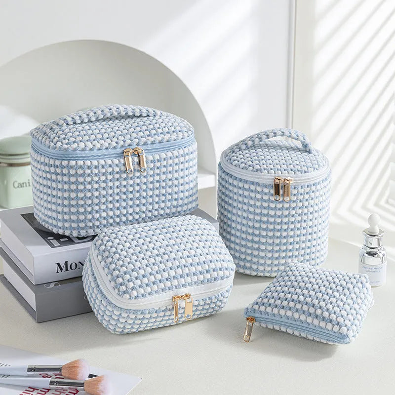 Set of four pink, khaki, and polka dot cube-shaped flannelette makeup bags for travel organisation.