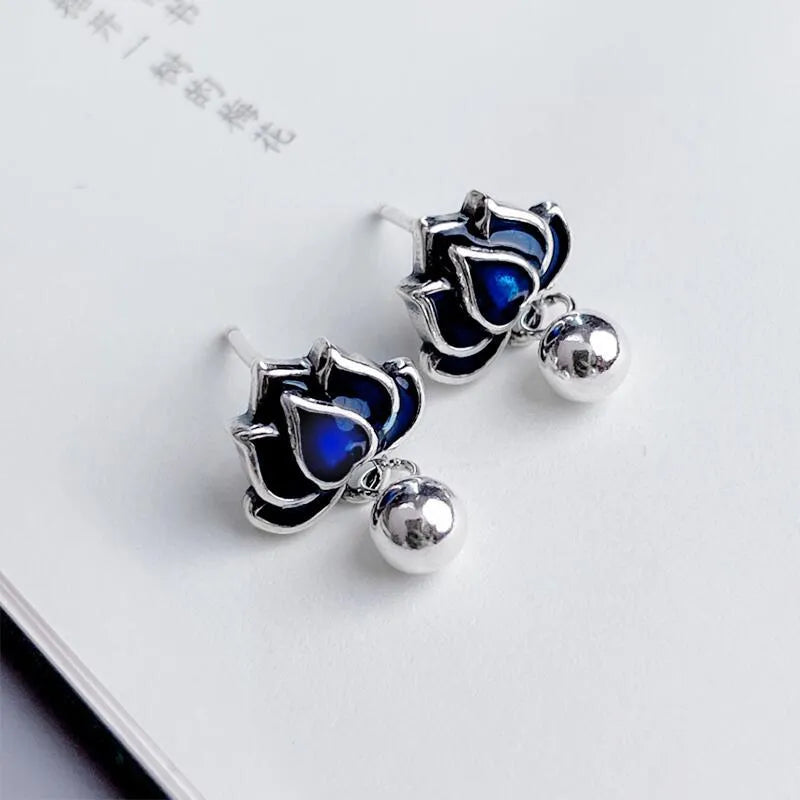 Blue lotus and seedpod earrings with dangling tassels on silver alloy posts.