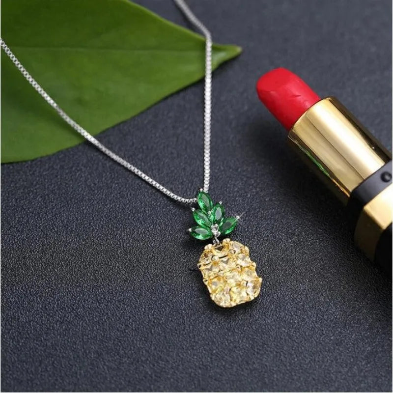 Silver plated women's necklace with a geometric pineapple pendant and diamond charm.