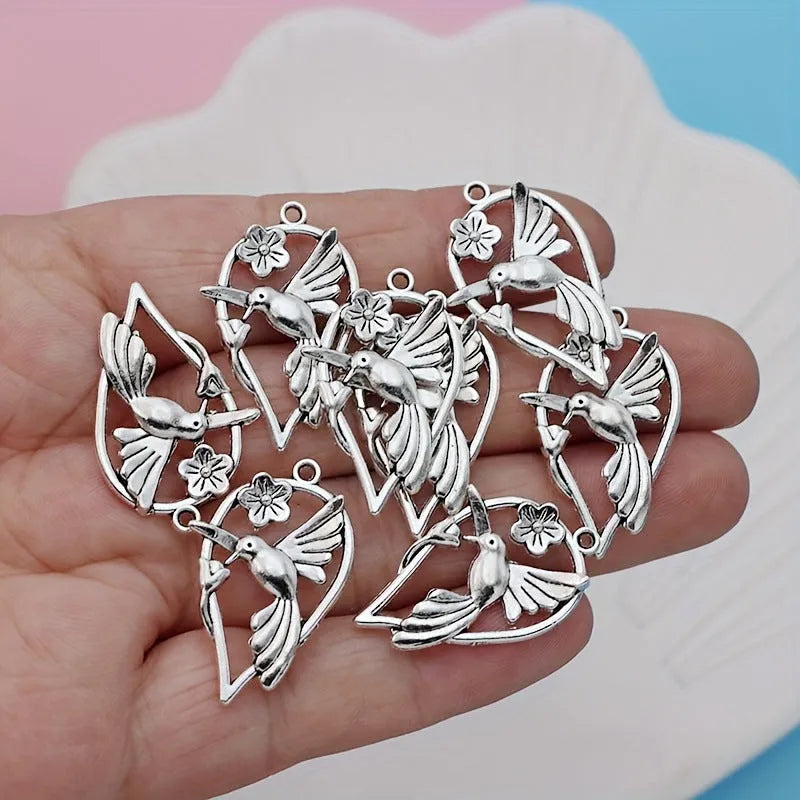 Close-up of a silver-grey alloy magpie pendant charm for DIY jewellery making on a white background.