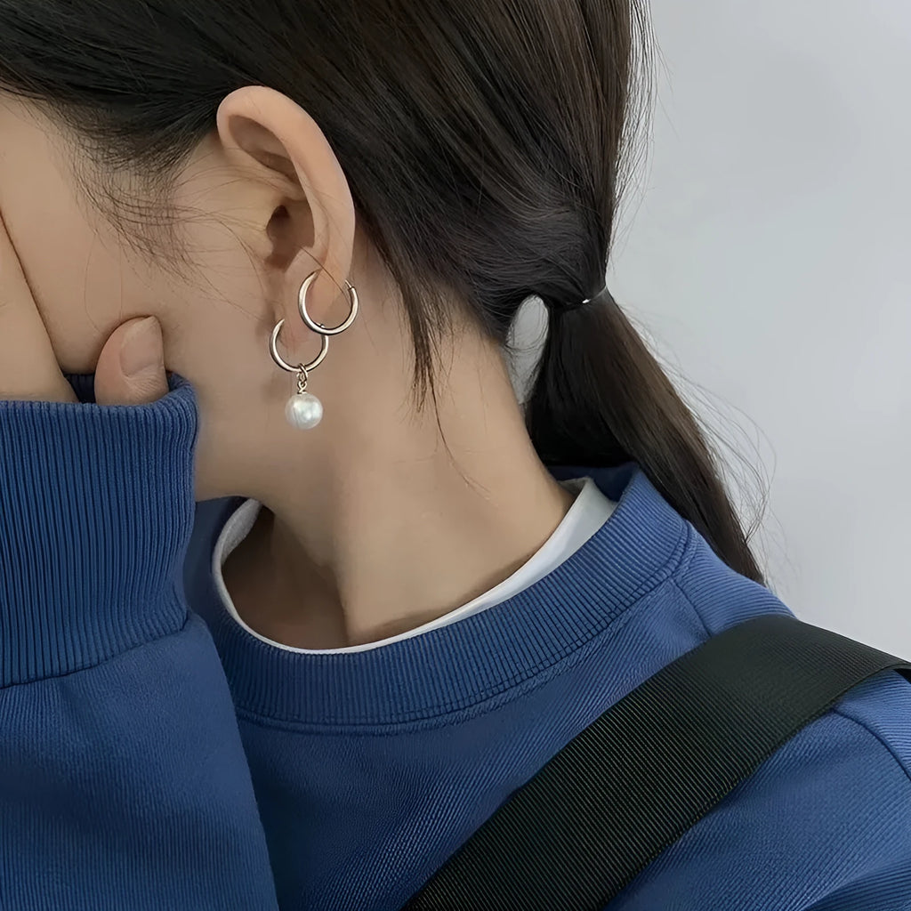 A pair of geometric-style pearl earrings for women with titanium steel posts.