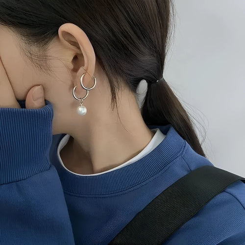 A pair of women's alloy earrings with a geometrical shape and a central round pearl.