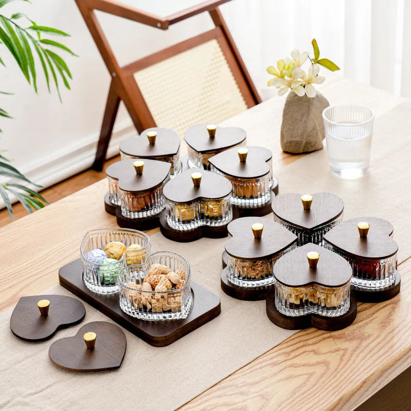 Glass fruit and snacks serving platter with multiple compartments and transparent heart-shaped lids in a retro style.