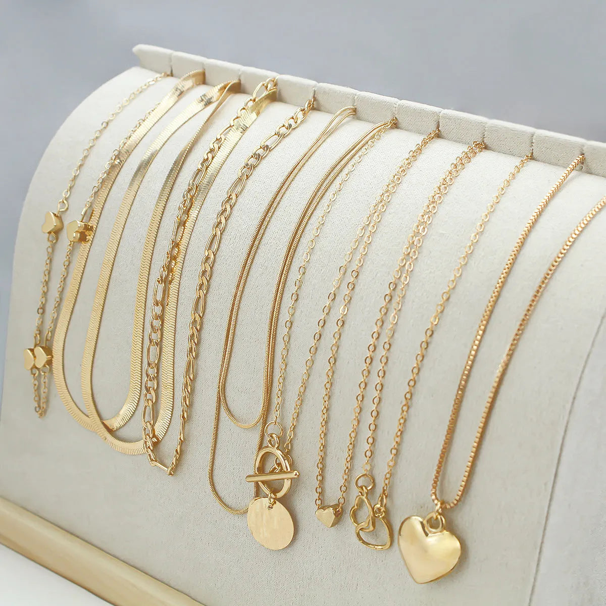 Set of ten simple gold women's necklaces with alloy pendants on snake bone chains.