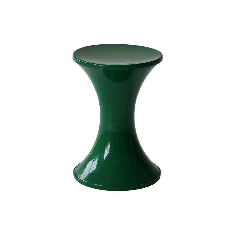 Plastic hourglass-shaped shoe changing stool shown in green, placed on a wooden floor.