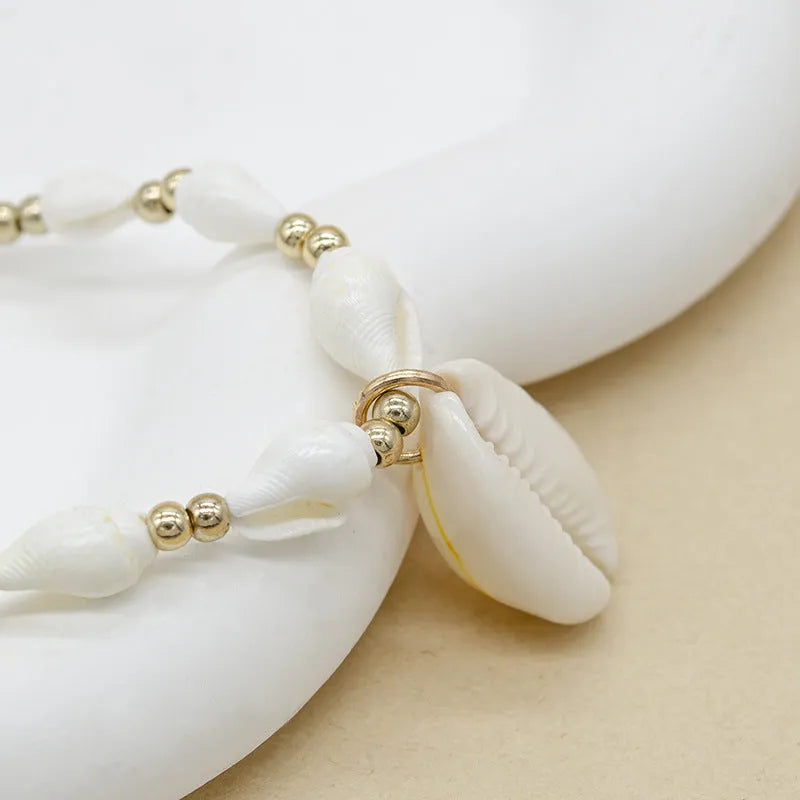 White conch-shaped mother pearl shell pendant necklace on a regular chain for women.