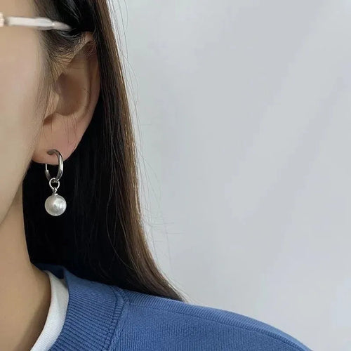 A pair of women's alloy earrings with a geometrical shape and a central round pearl.