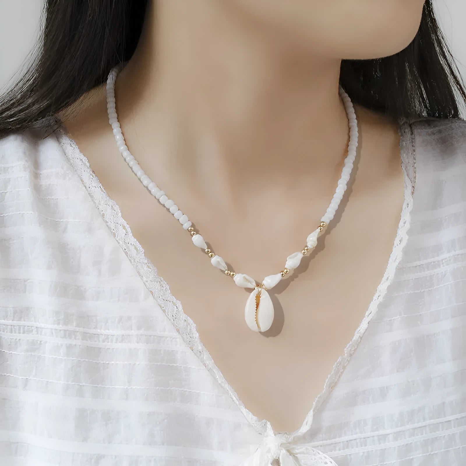 White conch-shaped mother pearl shell pendant necklace on a regular chain for women.