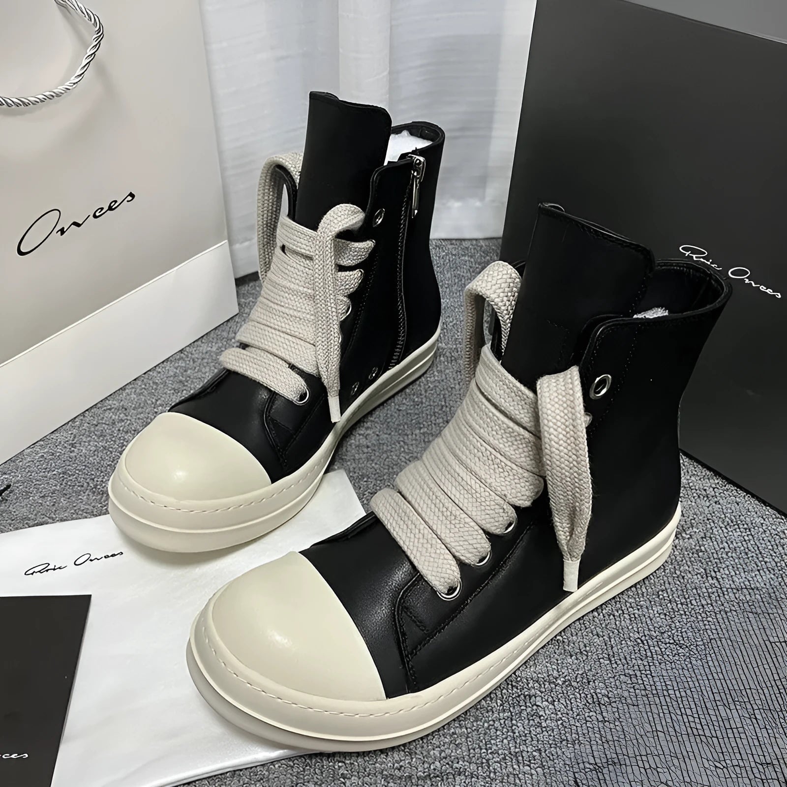 Black high-top leather boots with side zipper and round toe on a white background.