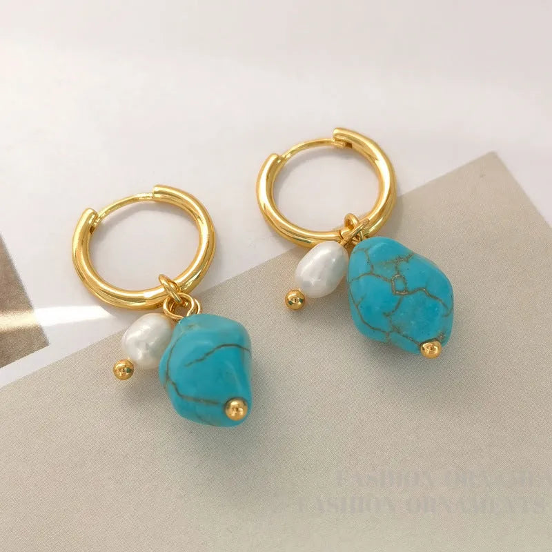 A pair of geometric copper clip-on earrings featuring irregular blue-green turquoise stones and white cultured pearls.