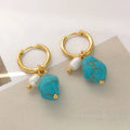 A pair of geometric copper clip-on earrings featuring irregular blue-green turquoise stones and white cultured pearls.