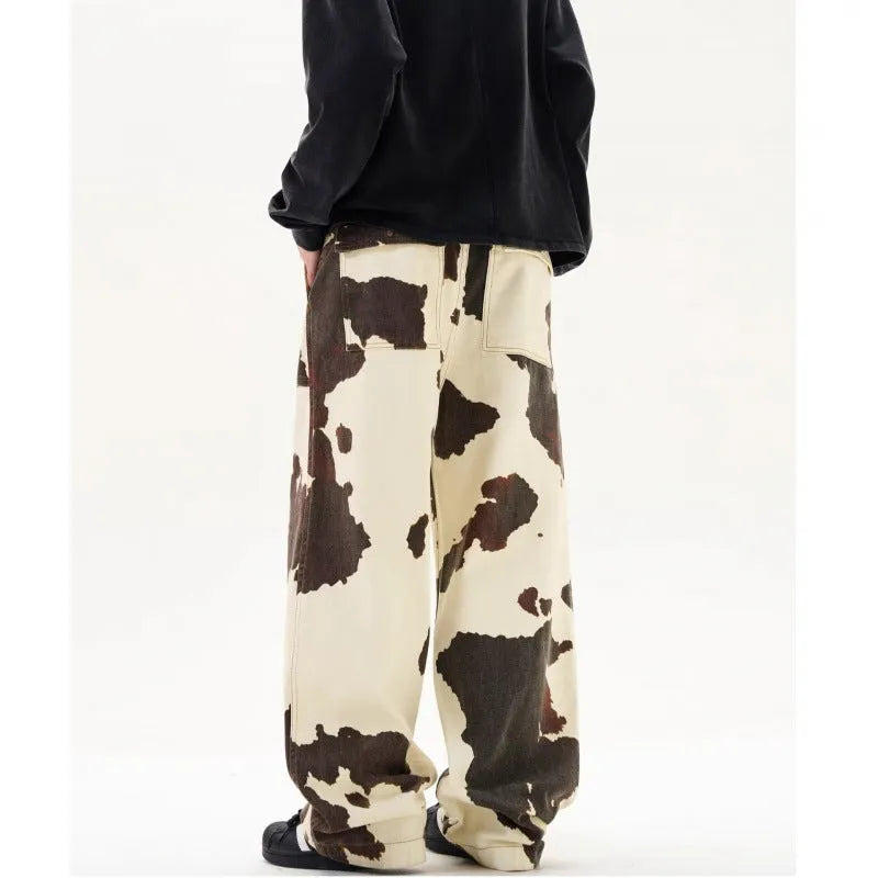 Men's straight-leg casual trousers featuring a black and white cow print pattern with a button fly.