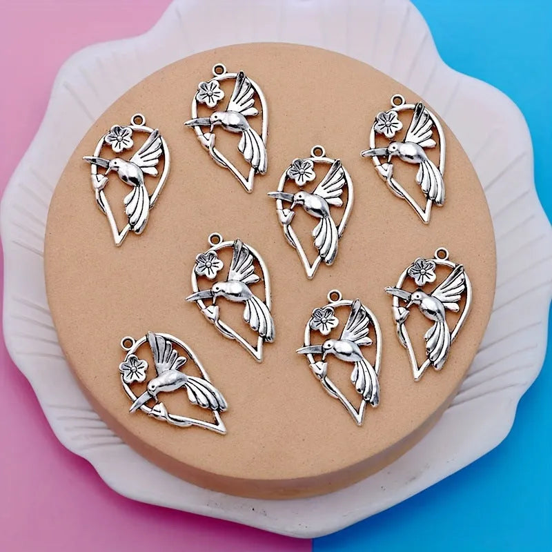 Close-up of a silver-grey alloy magpie pendant charm for DIY jewellery making on a white background.