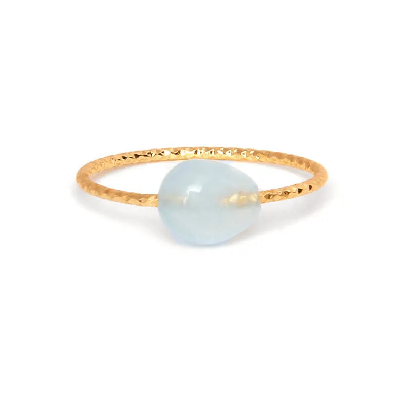 Women's geometric ring made from colourful agate stone on a neutral background.