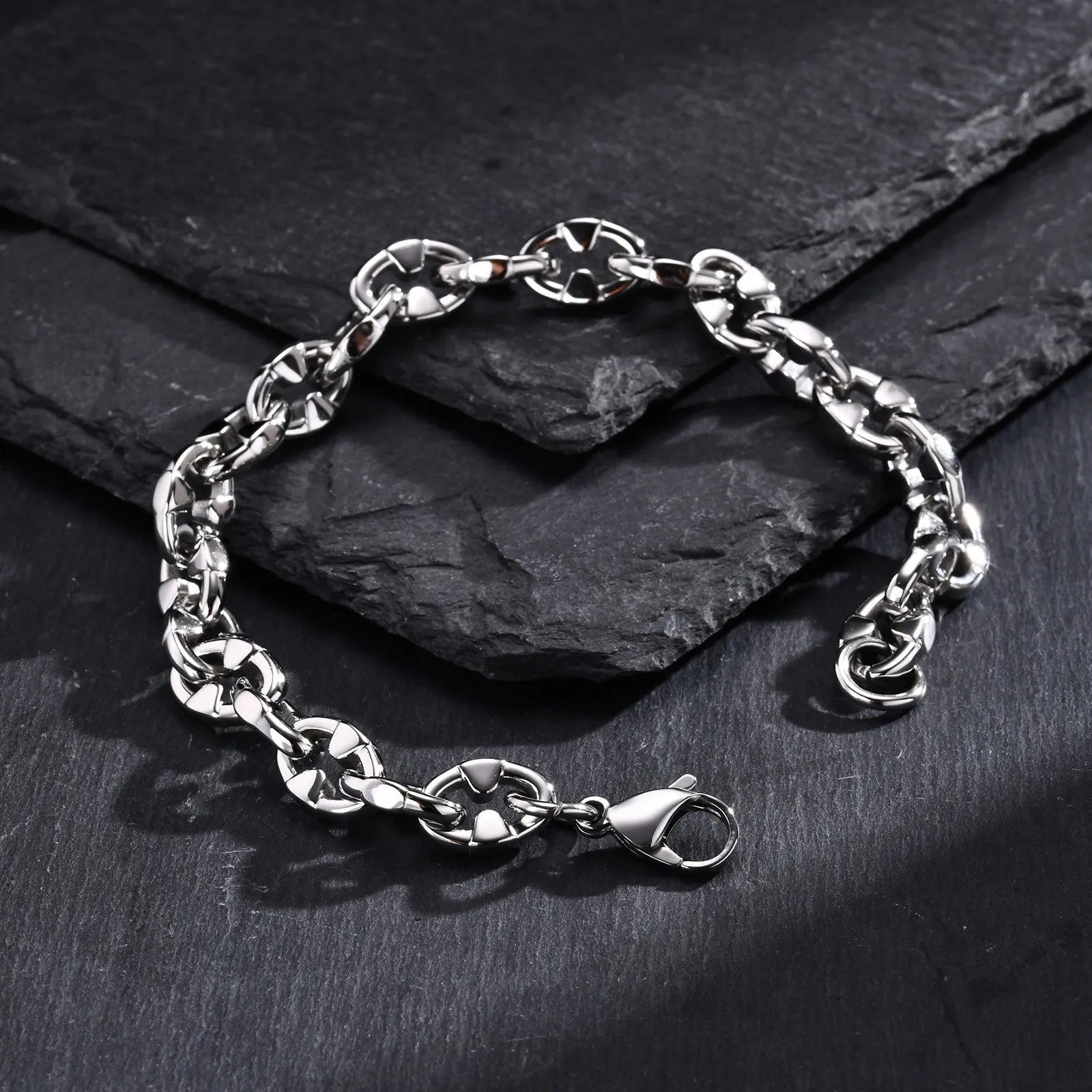 Thick stainless steel geometric link bracelet in steel colour on a wrist.