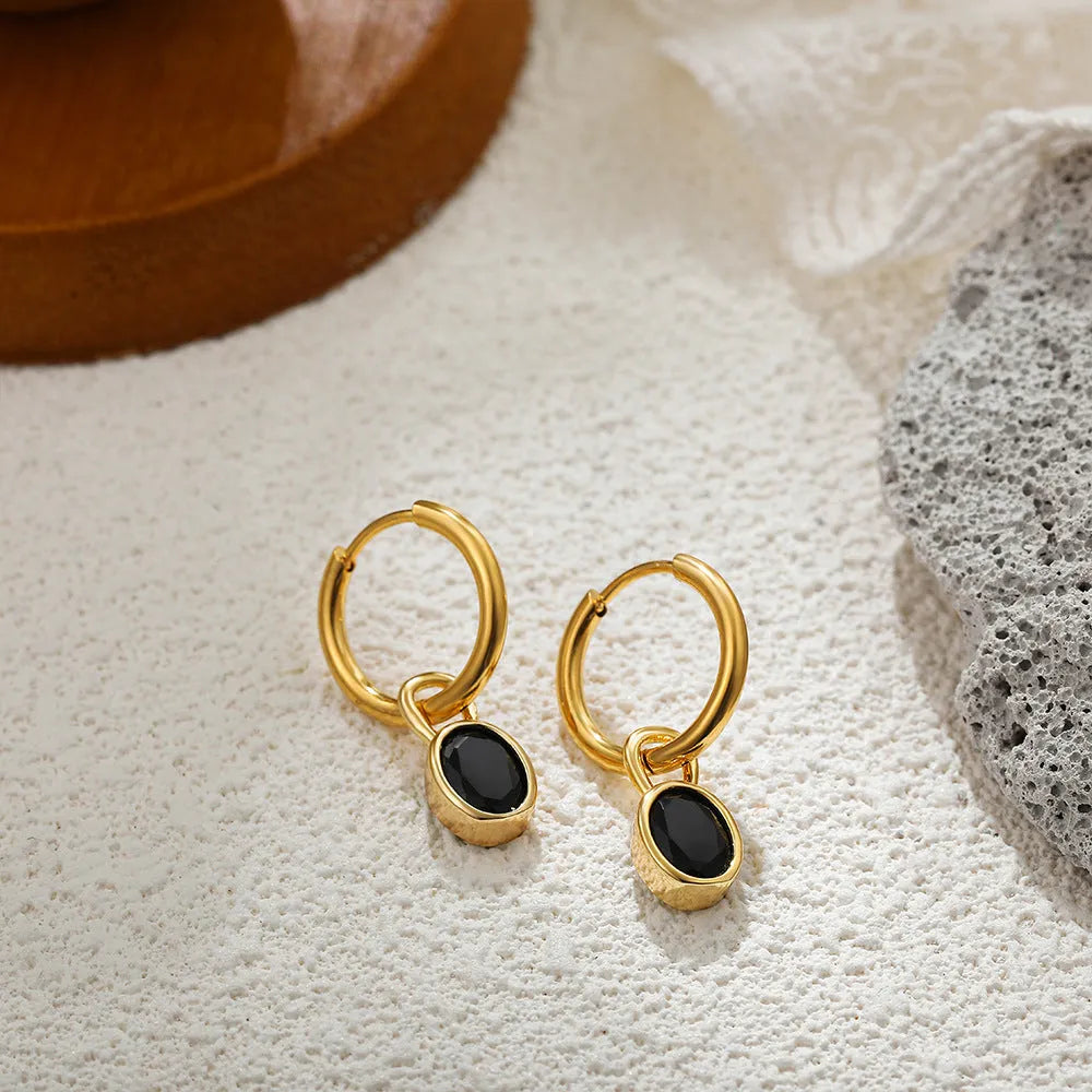 Close-up of a women's retro-style oval zircon earring in copper, showing elliptical stone setting and textured metal finish.
