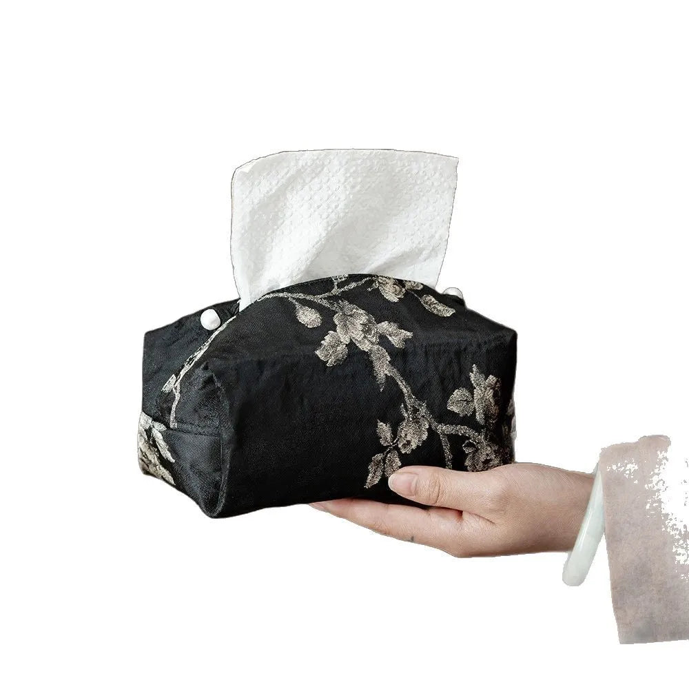 White embroidered plum blossom tissue box cover with fabric texture, shown next to a standard tissue carton for scale.