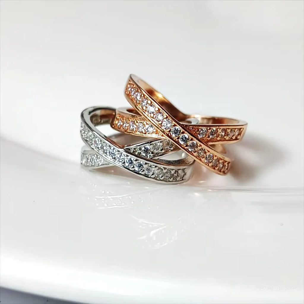 Geometric heart-shaped cross ring with micro-inlaid zircon in silver or rose gold electroplated finish.