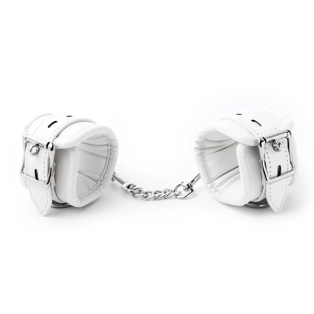 White PU sponge bondage handcuffs, foot cuffs, and neck scarf set on a plain background.