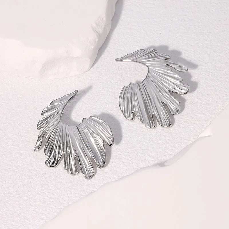 A pair of stainless steel stud earrings in a leaf shape, shown in gold colour and steel colour finishes.