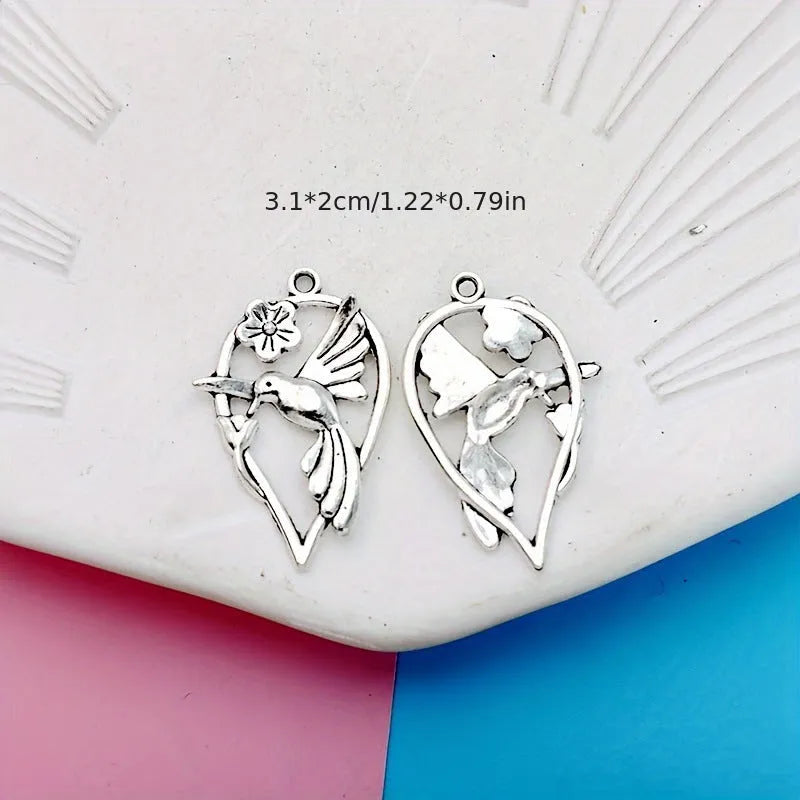 Close-up of a silver-grey alloy magpie pendant charm for DIY jewellery making on a white background.