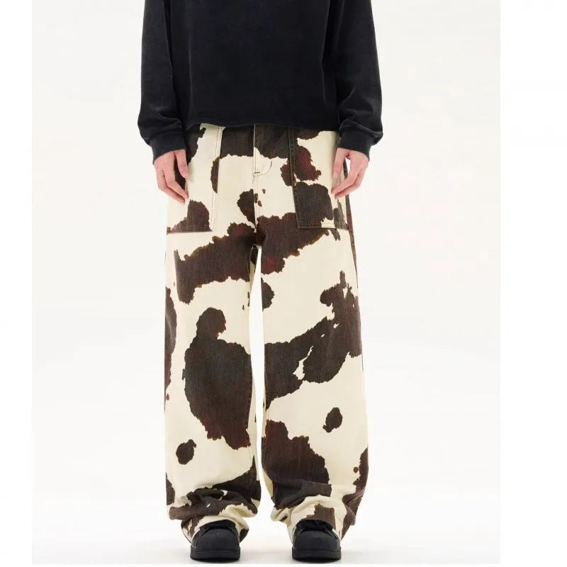 Men's straight-leg casual trousers featuring a black and white cow print pattern with a button fly.