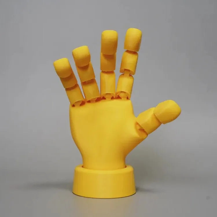 Yellow movable joint hand prop ornament with articulated fingers on a neutral background.