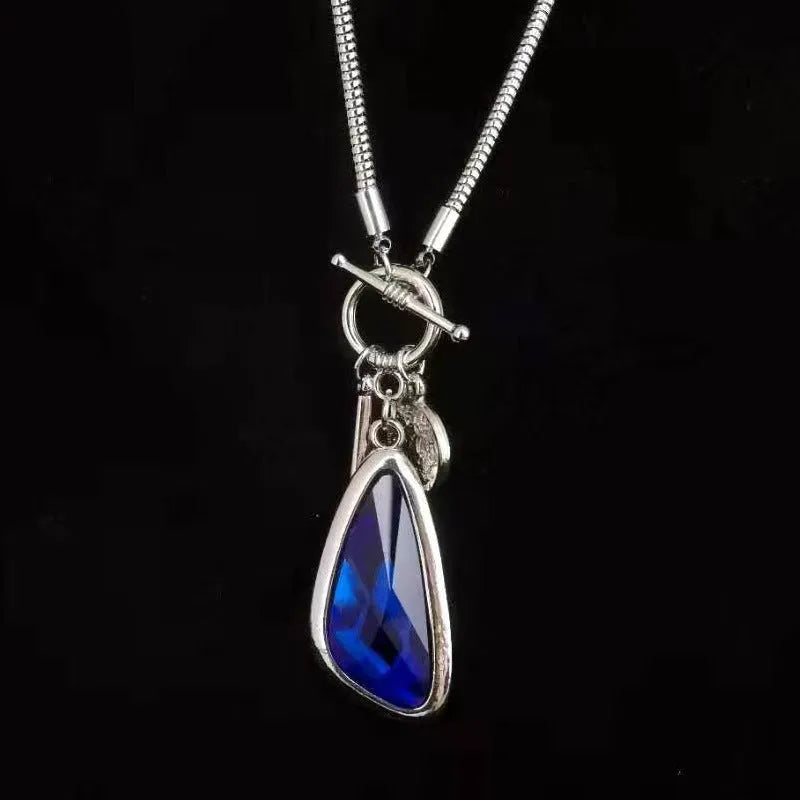 Geometric alloy pendant with plaid pattern on a long snake bones chain necklace.