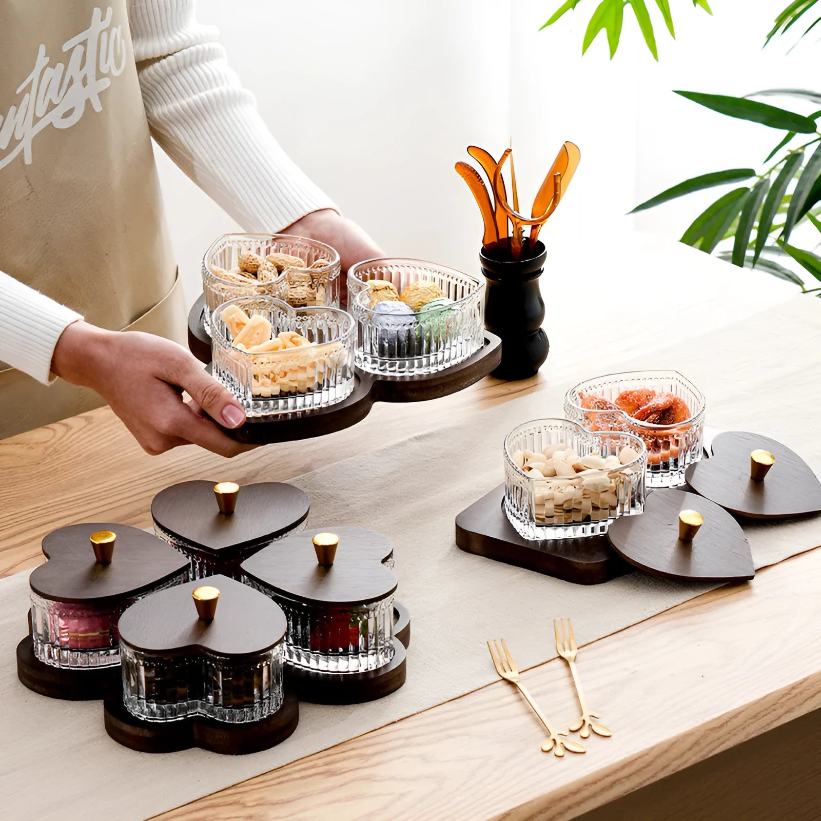 Glass fruit and snacks serving platter with multiple compartments and transparent heart-shaped lids in a retro style.