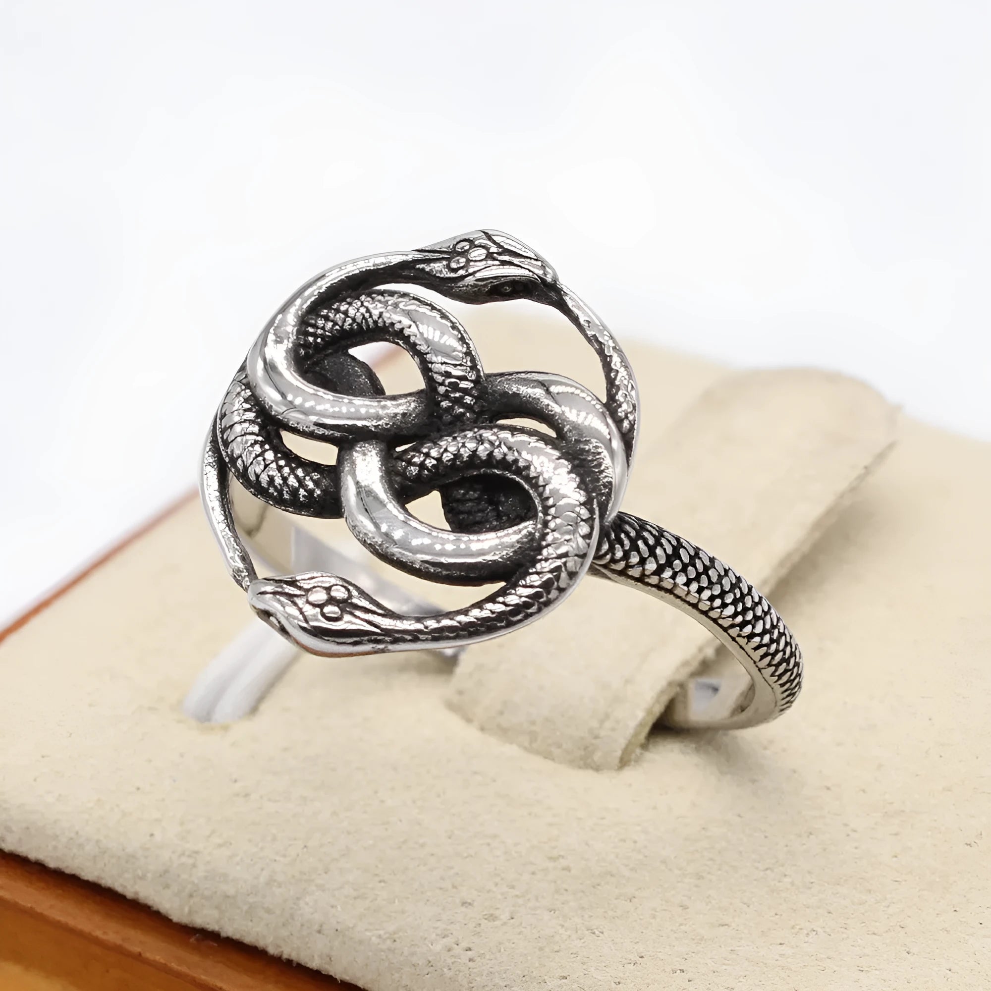Close-up of a retro-style titanium steel double snake ring in a steel colour on a hand.